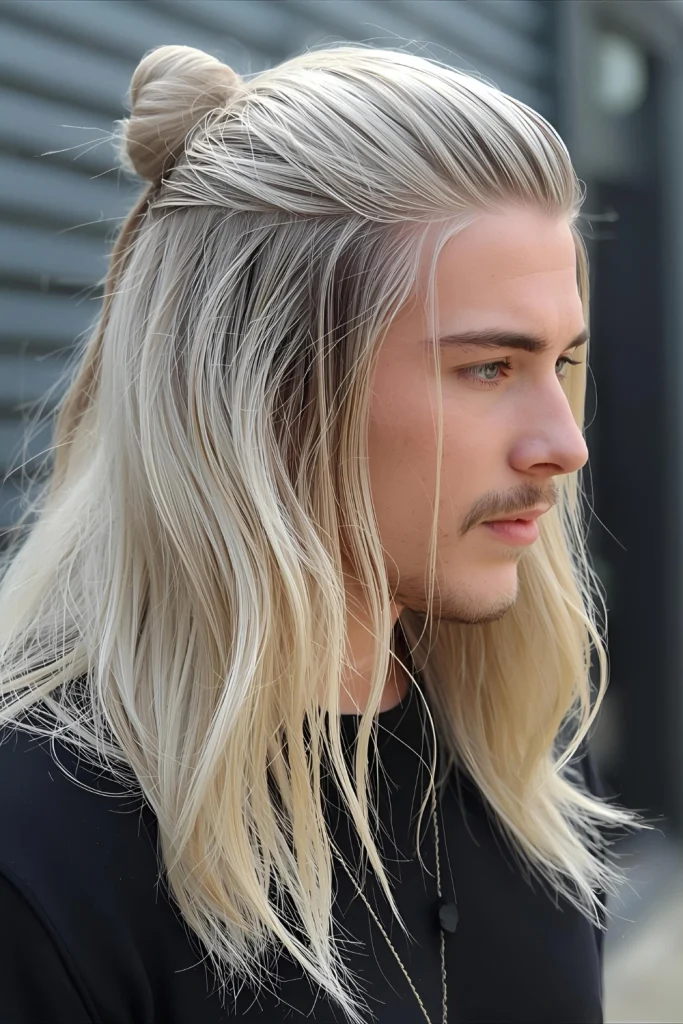 Ice Blonde Man Bun Longer hair pulled into a man bun showcases multiple dimensions of platinum tones from roots to ends.