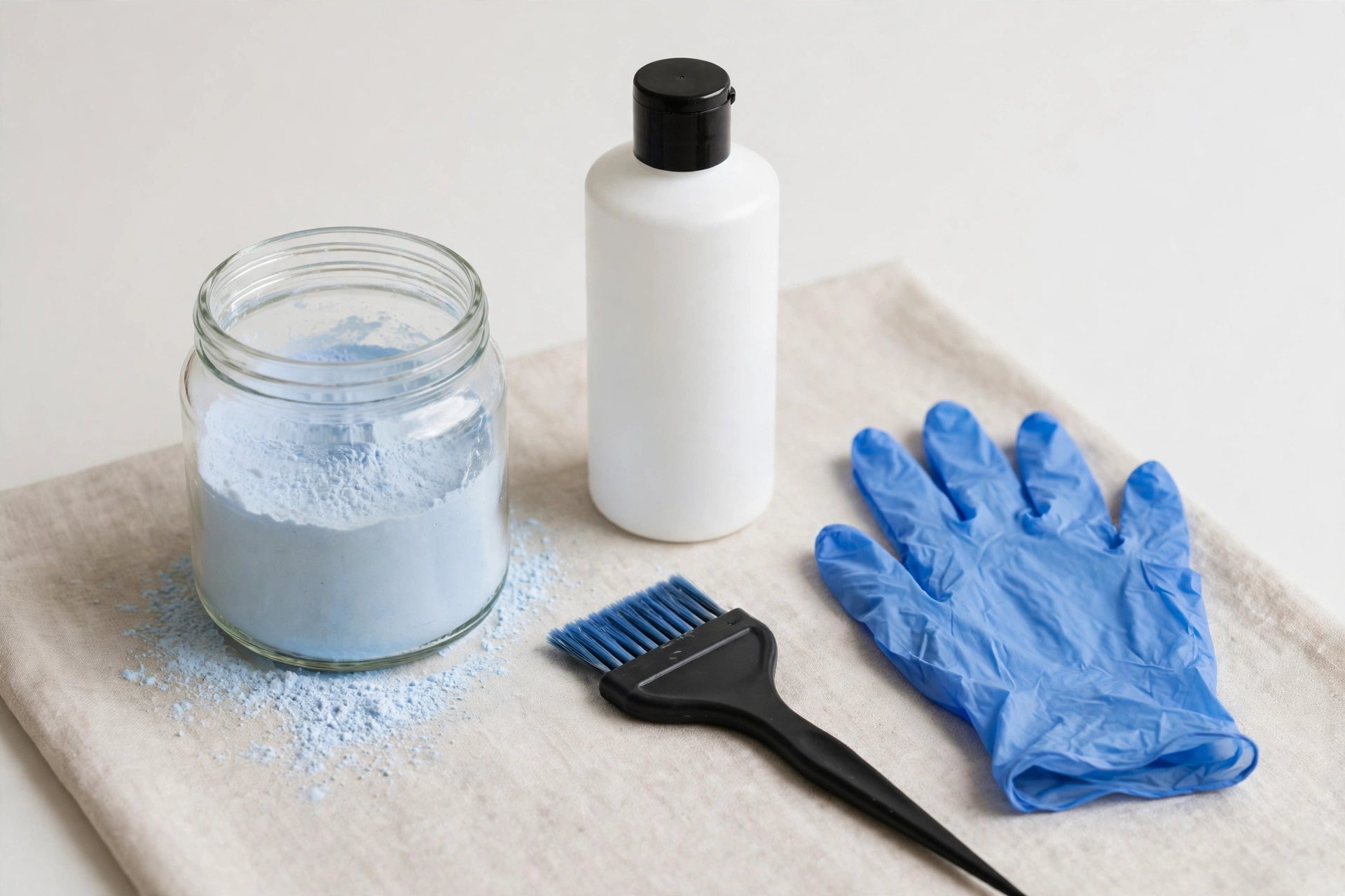 DIY hair bleaching kit with bleach powder, developer, brush and gloves on a table, product photography