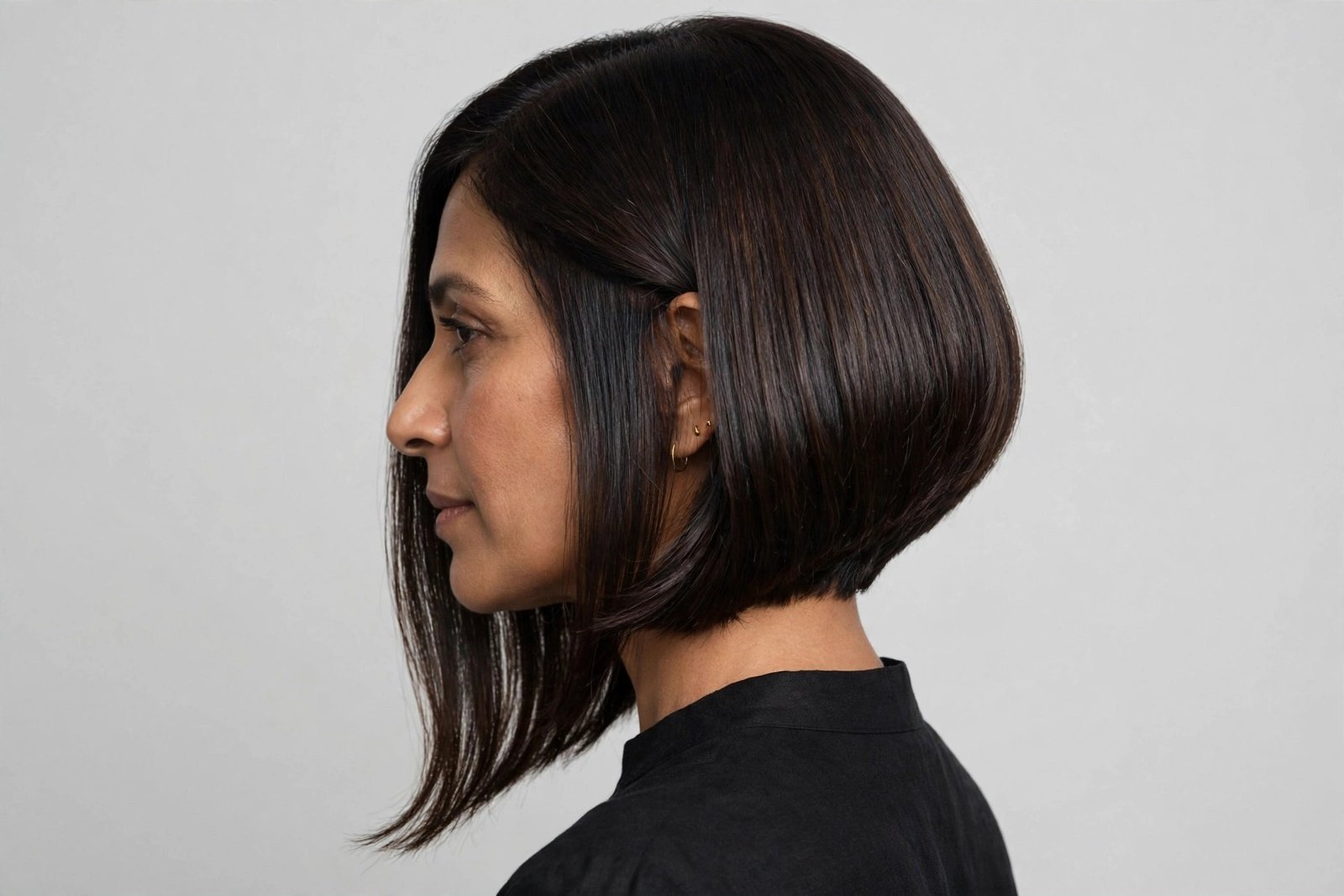 Woman with soft A-line long layered bob, dark brunette hair longer in front, editorial hair photography