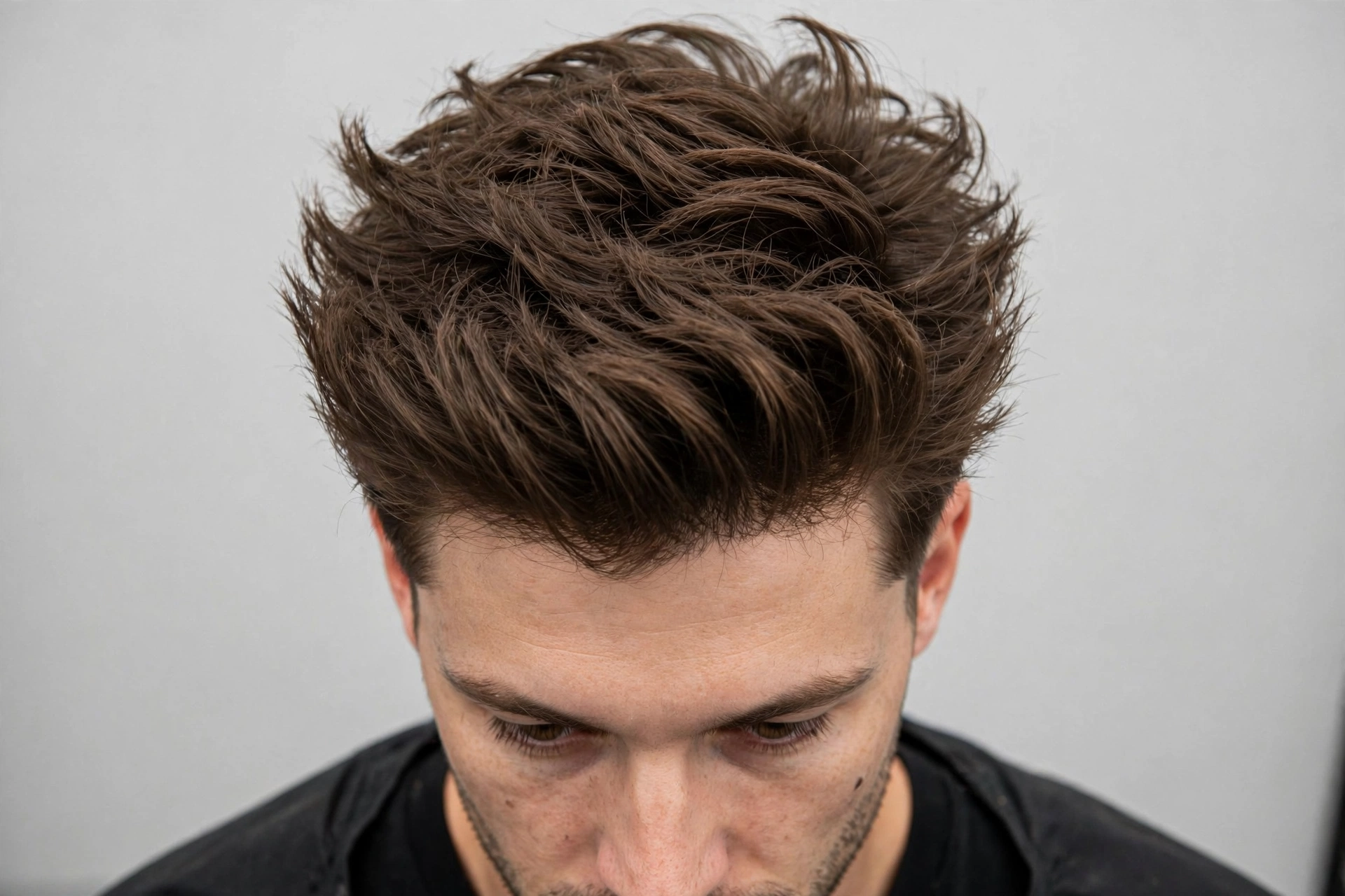 Short textured wings haircut on a man with fine hair, showing volume at the crown